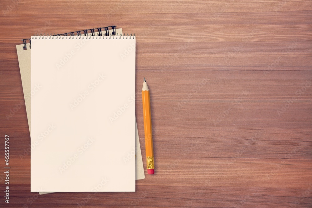 White empty notebooks and yellow pencil on the desk White empty notebooks and yellow pencil on the desk