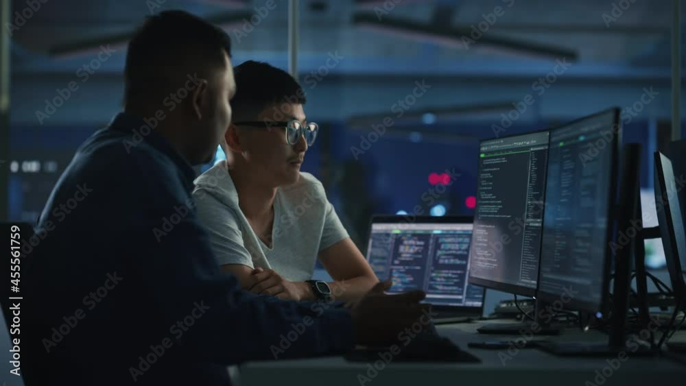 Teamwork In Diverse Office at Night: Project Manager Talks with Creative Solutions Specialist, They Discuss App Code Computer. Stylish Professionals Programming, Create e-Commerce Software