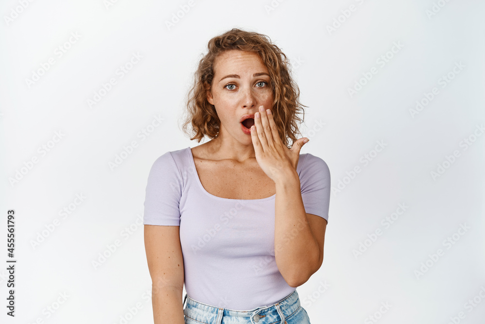 Image of girl fakes surprise, cover opened mouth and looking shocked at camera, white background Image of girl fakes surprise, cover opened mouth and looking shocked at camera, white background