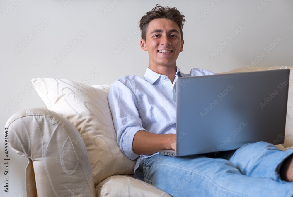 Smart working with laptop computer on sofa at home - young people with technology - modern lifestyle with remote work stock photo Smart working with laptop computer on sofa at home - young people with technology - modern lifestyle with remote work stock photo