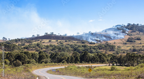 Hills with smoke and fire in rural area.