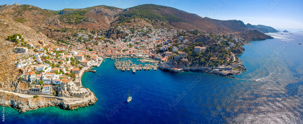 Aerial drone panoramic photo of the picturesque port and main village of Hydra (or Ydra) island at sunset. Hydra is a top tourist destination with neoclassic houses located in Saronic gulf, Greece.