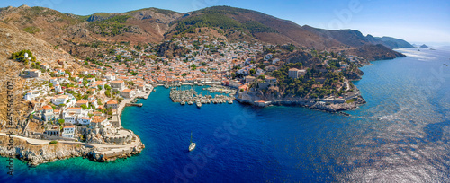 Fototapeta Naklejka Na Ścianę i Meble -  Aerial drone panoramic photo of the picturesque port and main village of Hydra (or Ydra) island at sunset. Hydra is a top tourist destination with neoclassic houses located in Saronic gulf, Greece.
