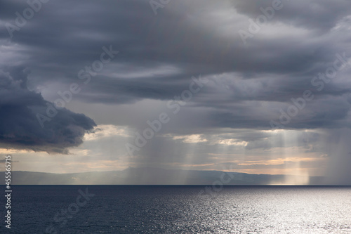 Sun breaking through storm clouds over the ocean