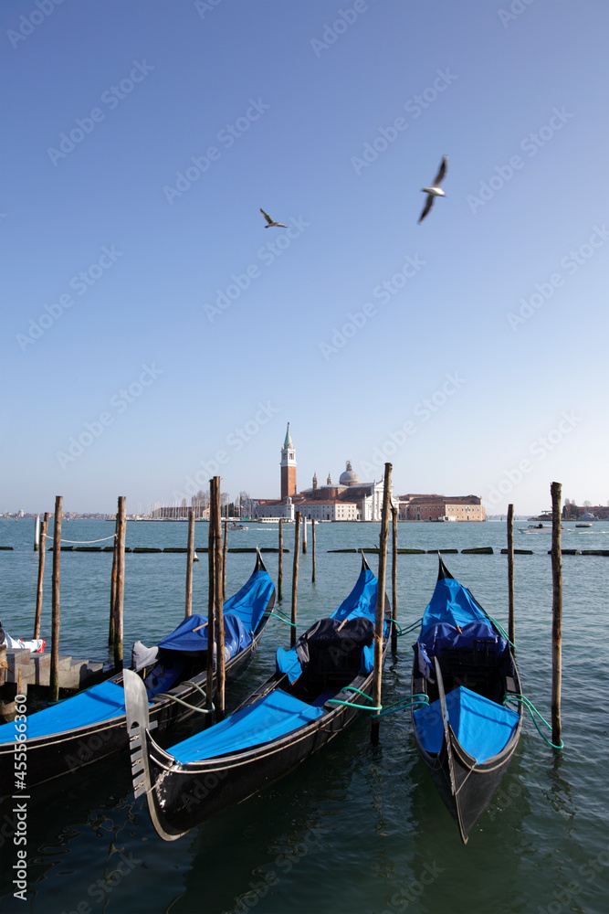 Gondolas in St. Mark's square with Saint George's island at sunrise, Venice, Italy