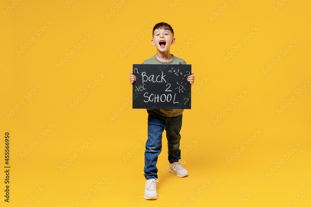 Young school boy 5-6 years old in t-shirt casual clothes hold card sign with back 2 school text isolated on plain yellow background children studio portrait Childhood kids education lifestyle concept. Young school boy 5-6 years old in t-shirt casual clothes hold card sign with back 2 school text isolated on plain yellow background children studio portrait Childhood kids education lifestyle concept.