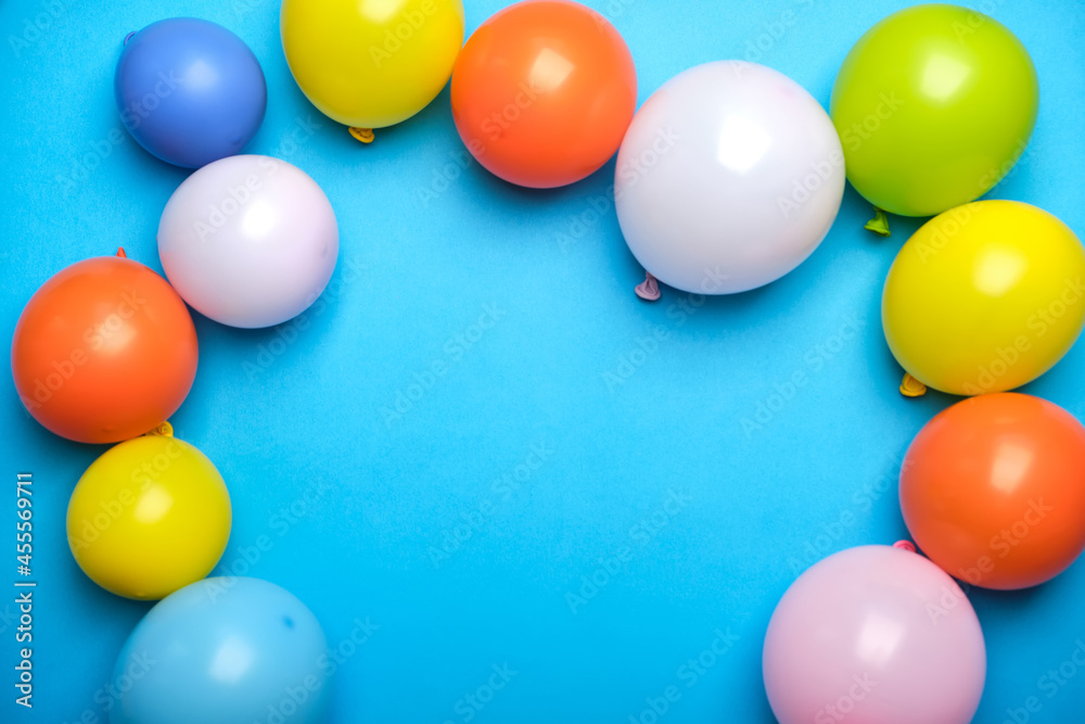 Colorful balloons on blue table top view.