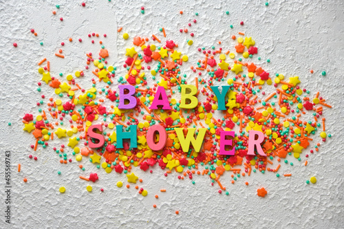 baby shower wooden words on colorful confetti, photo