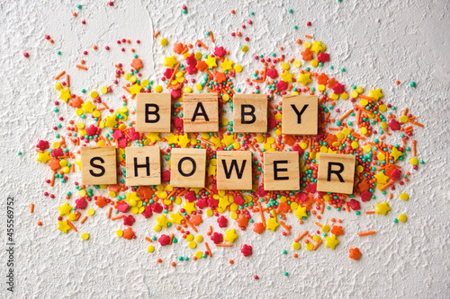 baby shower wooden words on colorful confetti, photo