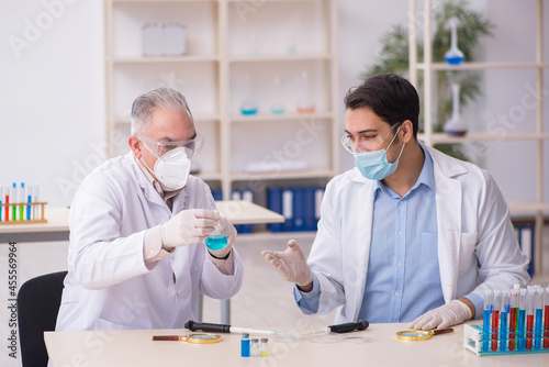 Two male chemists working at the lab during pandemic