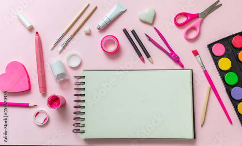 School supplies and blank notebook on pink color background, kids creativiy photo