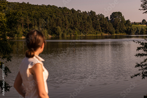 Photo of a girl close up on the background of a lake in the woods