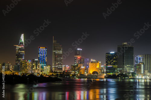 Colorfuly illuminated towers of Ho Chi Minh city from water at night