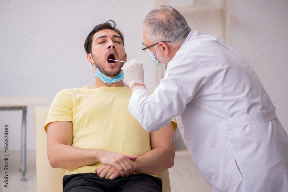 Young male patient visiting old male doctor otorhinolaryngologis