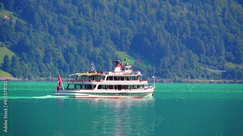 A pleasure boat (holiday cruiser) with passengers floats on a Swiss lake with azure water