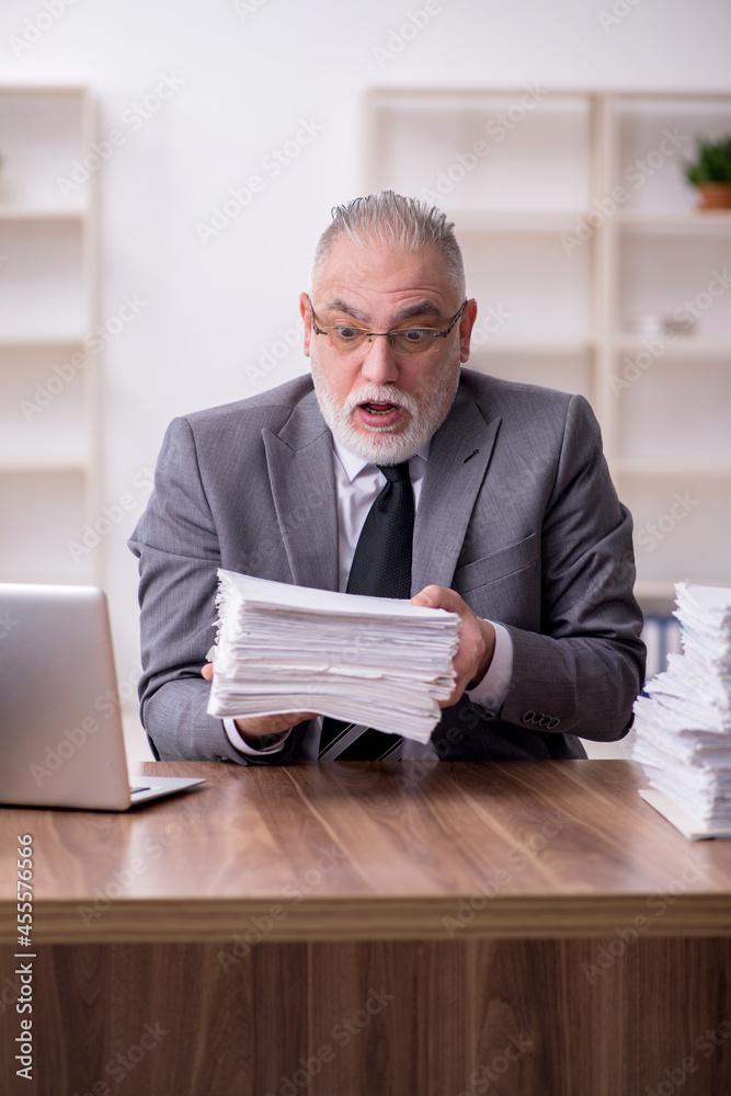 Old male employee working in the office Old male employee working in the office