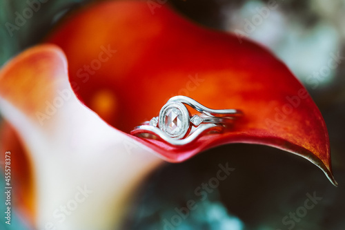 Clear jeweled silver-colored ring inside orange flower photo