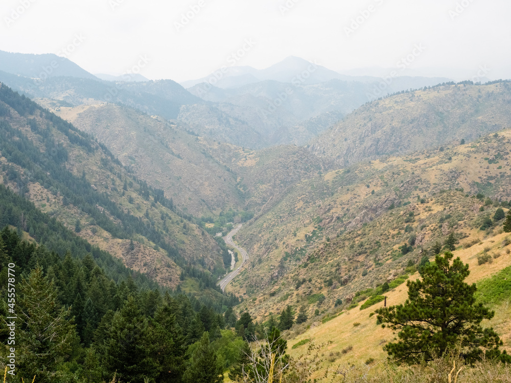 Fototapeta premium Cascades of mountains come together around a winding road below.
