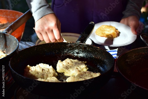 Street food cooking. Deep-fried potato balls on background of preheated cast-iron pan