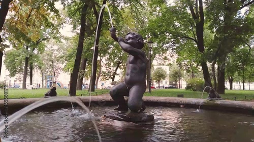 the view of one of the fountains a little boy, cupid, blows a horn in the Nikolskiy garden near St. Nicholas Naval Cathedral in Saint-Petersburg , Russia
