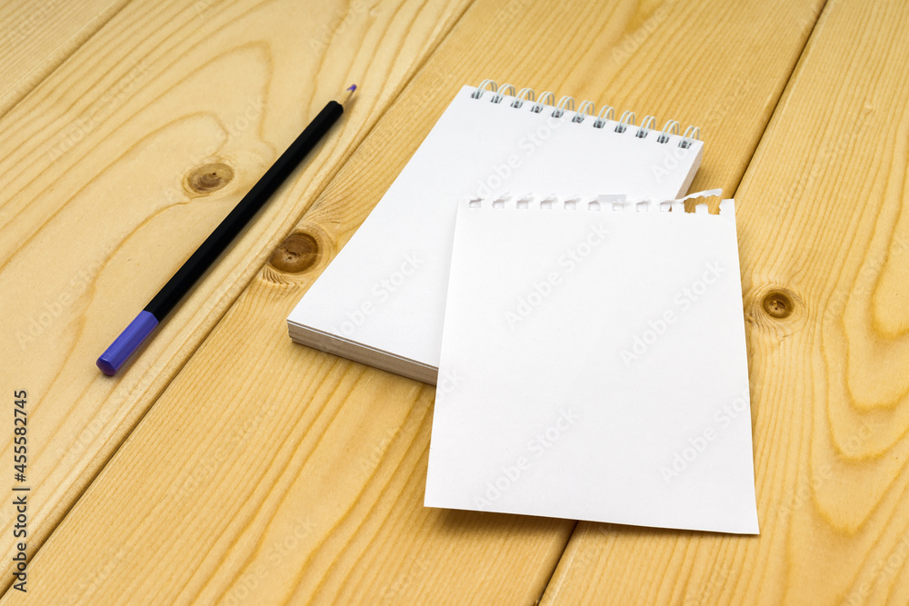 blank notepad with torn off white sheet and pencil on wooden background blank notepad with torn off white sheet and pencil on wooden background