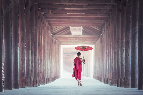 Monk holding bambbo umbrella photo