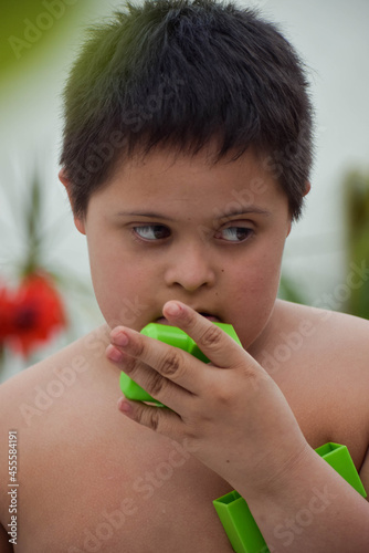 Portrait of  boy with down syndrome holding piece of blocks