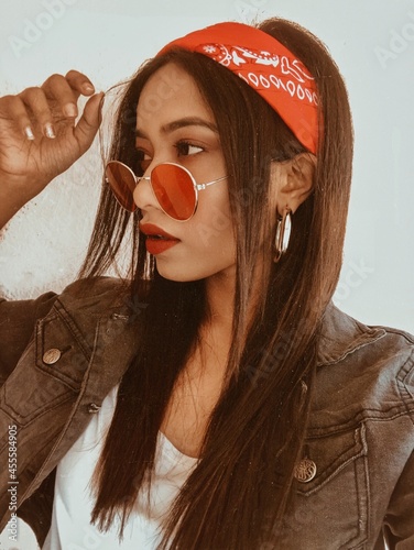 Portrait of woman with bandana and red sunglasses looking away