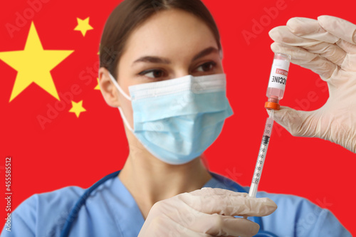Female doctor with vaccine against national flag of China photo