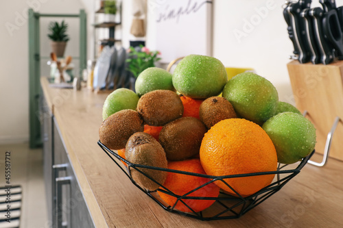Basket with fresh fruits on counter in kitchen, closeup
