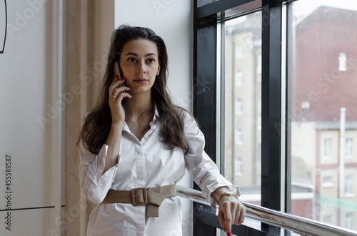 Woman in long sleeve shirt standing beside glass window photo