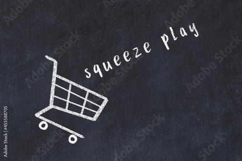 Chalk drawing of shopping cart and word squeeze play on black chalboard. Concept of globalization and mass consuming photo