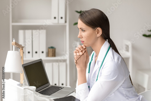 Praying female doctor in cl...