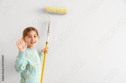 Little girl painting wall i...