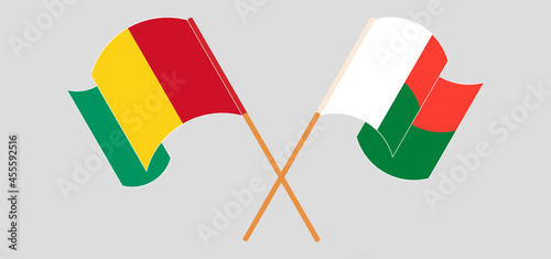 Crossed and waving flags of Guinea and Madagascar