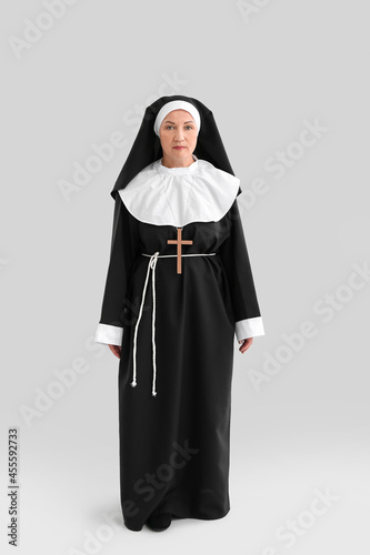 Mature nun on light background