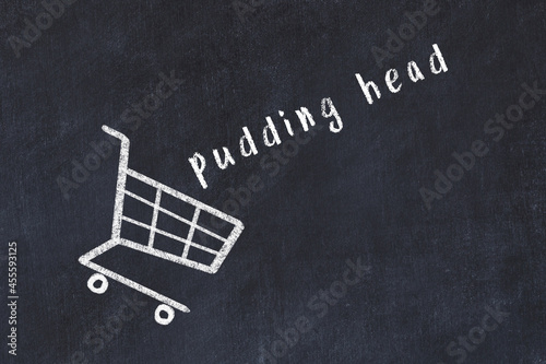 Chalk drawing of shopping cart and word pudding head on black chalboard. Concept of globalization and mass consuming photo