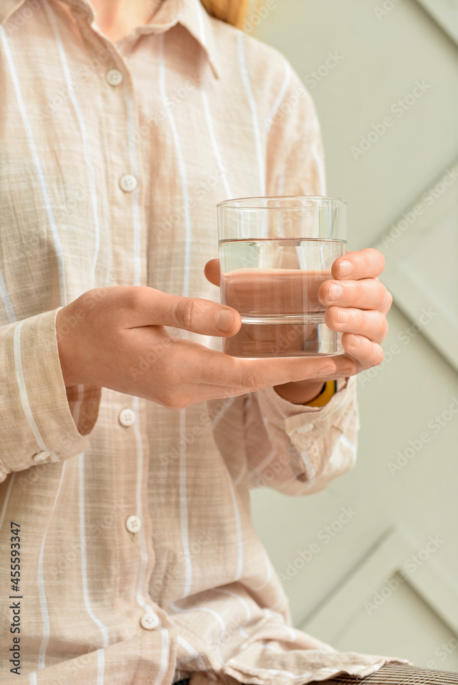 Woman with glass of water on light background Woman with glass of water on light background