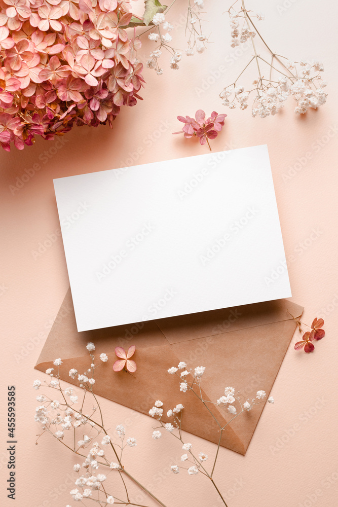 Wedding invitation or greeting card mockup with envelope and pink hydrangea and gypsophila flowers decorations. Wedding invitation or greeting card mockup with envelope and pink hydrangea and gypsophila flowers decorations.
