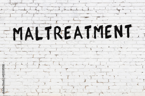 Inscription maltreatment painted on white brick wall