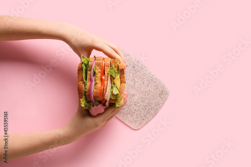 Woman holding tasty sandwic...