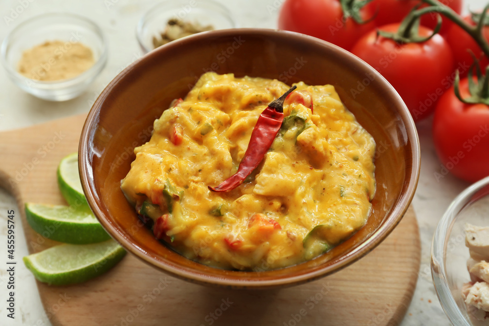 Bowl of tasty chicken curry on table, closeup