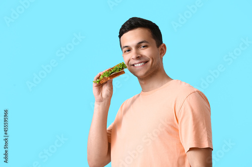Young man with tasty sandwi...