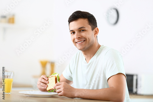 Young man with tasty sandwi...