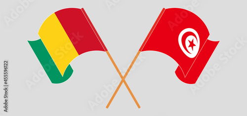 Crossed and waving flags of Guinea and Tunisia