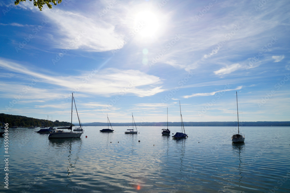 a scenic view of sailing boats in the sun at the bay on lake Ammersee in Germany	
