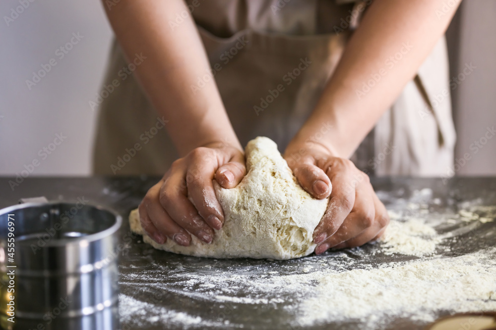 Female chef preparing dough on kitchen table, closeup Female chef preparing dough on kitchen table, closeup