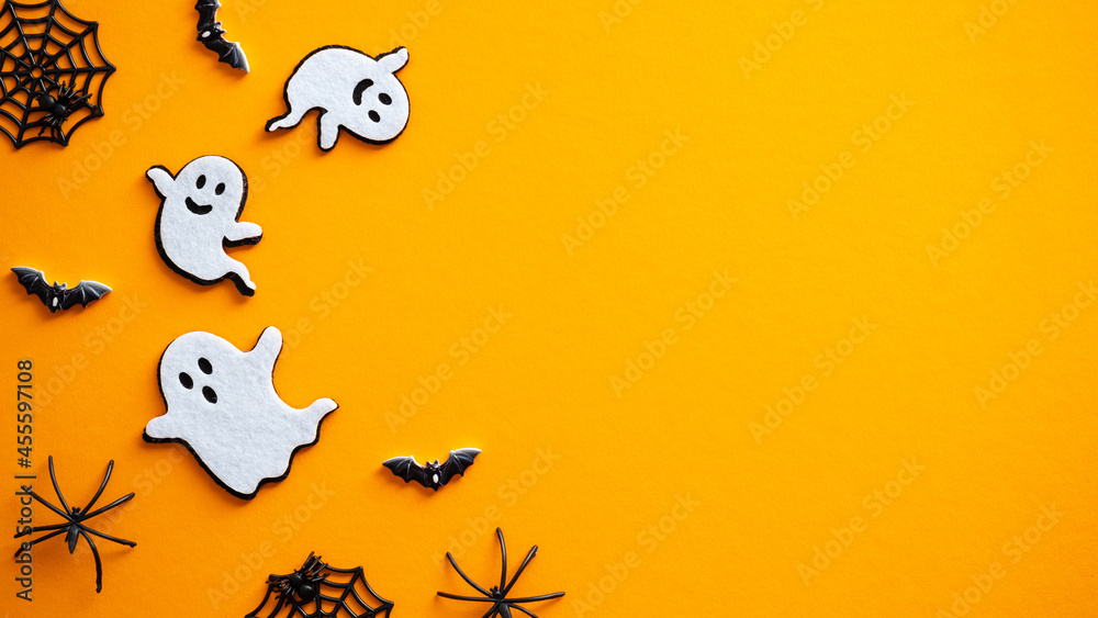 Naklejka premium Halloween background with ghosts, bats, spiders, decorations. Halloween party invitation card mockup. Flat lay, top view, copy space.