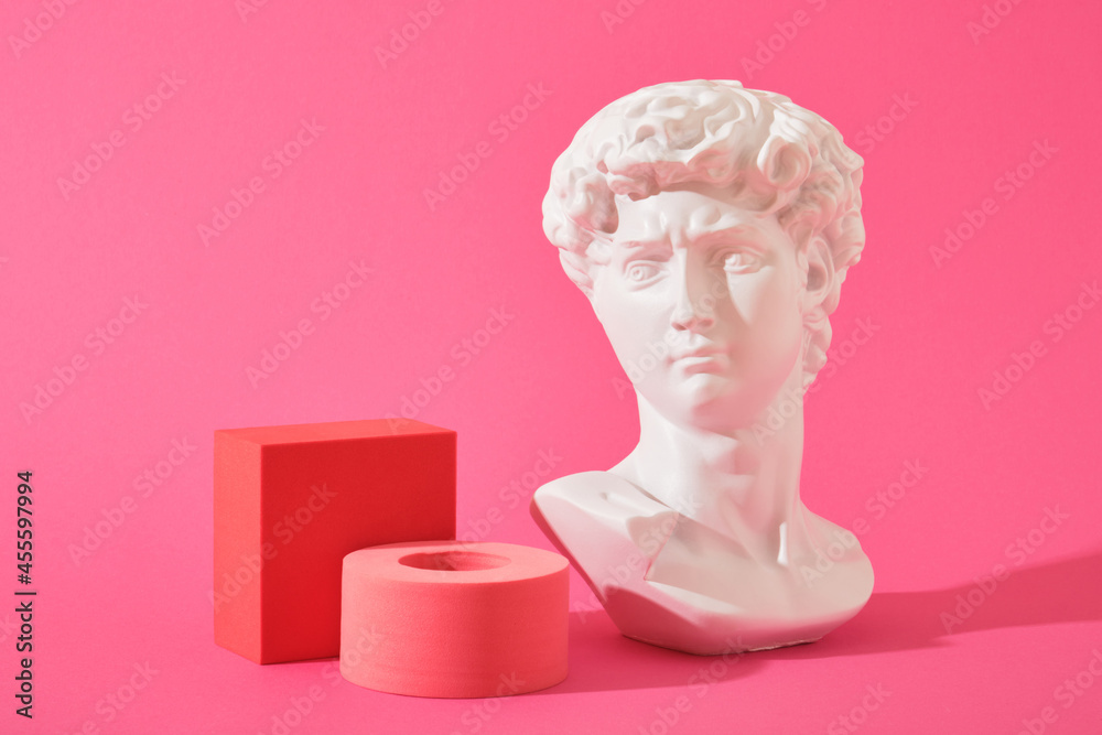 white decorative sculptural bust and several pink geometric coasters on a pink background white decorative sculptural bust and several pink geometric coasters on a pink background