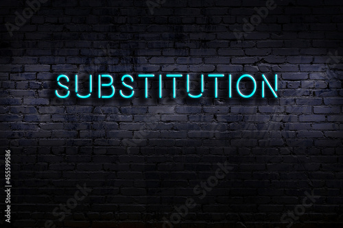 Neon sign. Word substitution against brick wall. Night view photo
